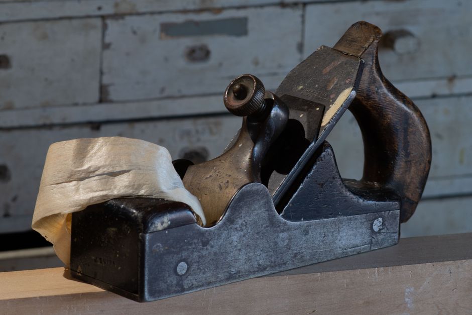 Classic wooden hand plane in a historic Ayr, Scotland woodshop, emphasizing craftsmanship.